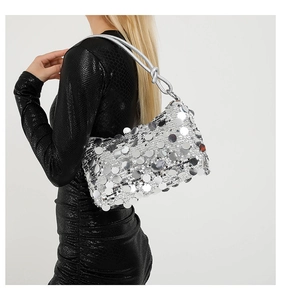 Detail of silver sequin shoulder bag with knot strap and metallic reflective texture