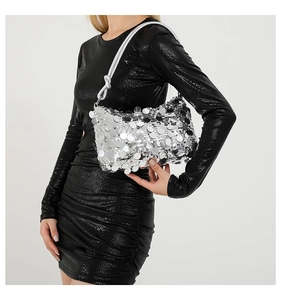 Detail of silver paillette handbag featuring large reflective sequins and knotted strap