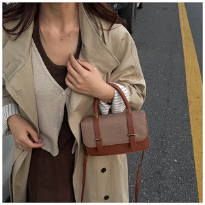 Détail du sac bandoulière en cuir marron et tissu pied-de-poule avec boucle dorée
