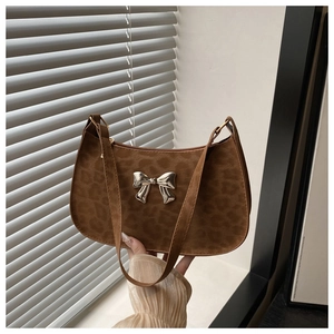 Détail du sac bandoulière en suédine léopard avec un nœud métallique argenté