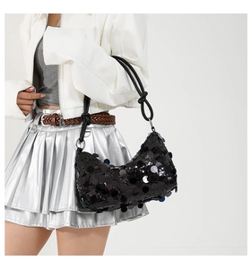 Detail of black sequined crescent bag with knotted rope strap and shimmering finish