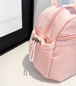Détail du sac en tissu rose montrant l'ouverture latérale à cordon et la texture