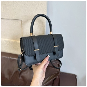 Vue détaillée du sac à main noir avec rabat texturé et finitions dorées élégantes
