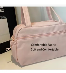 Détail du sac fourre-tout rose en nylon montrant le tissu souple et la poche zippée avant