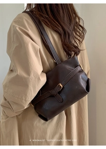 Detailed close-up of dark brown vintage tote bag with elegant metal buckle and leather texture