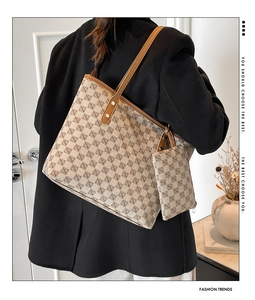 Detalle de bolso tote retro con estampado geométrico, correa de cuero y mini bolso