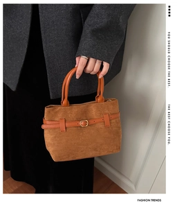 Détail d'un sac seau en daim marron avec boucle de ceinture et garniture dorée chic