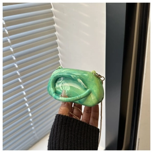 Dettaglio della mini borsa in acrilico marmorizzato verde con catena oro e manico integrato