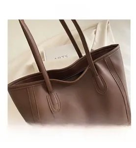 Detail view of large dark brown tote bag with matte texture and decorative side stitching