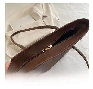 Detail shot of the smooth metal zipper closure on the vintage dark brown leather tote bag