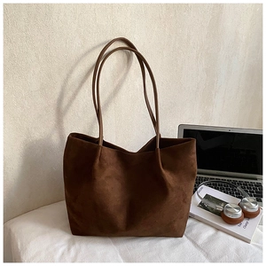 Macro detail of deep brown faux suede tote bag with slim straps and spacious interior
