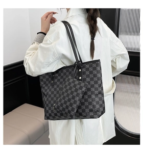 Detail view of large checkered tote bag with matching zipper pouch on model's shoulder