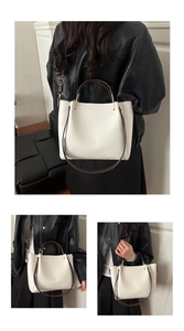 Vue détaillée du sac cabas blanc cassé avec poignées brunes et ferrures dorées
