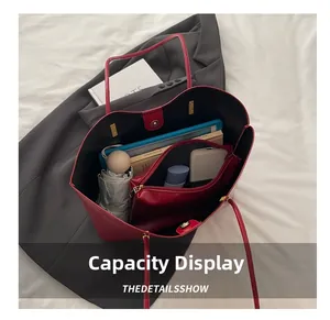 Interior storage space of large red wax leather tote bag with various accessories