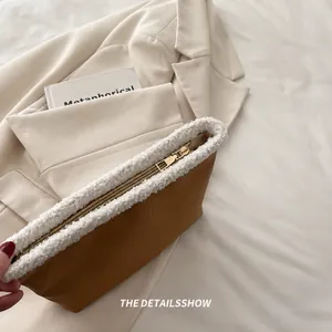 Dettaglio di una borsa invernale marrone con zip dorata fluida e bordo in peluche bianco