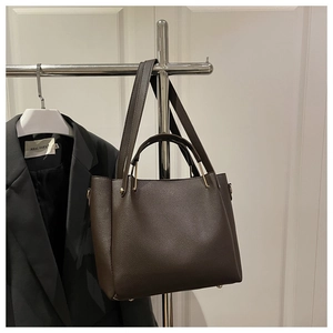 Vue détaillée du sac seau en cuir marron foncé avec poignée et bandoulière réglable