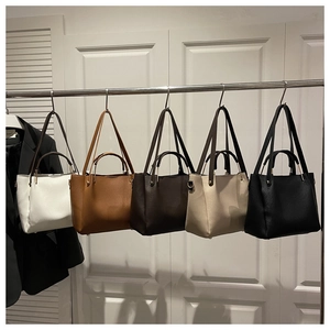 Cinq sacs cabas minimalistes en cuir grainé déclinés en blanc, marron et noir classique
