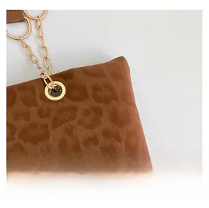 Dettaglio del tessuto leopardato e della tracolla a catena dorata della borsa