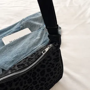 Vue détaillée de la fermeture éclair en métal argenté du sac fourre-tout à motif léopard