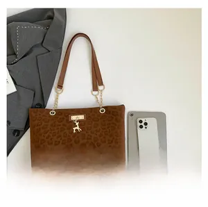 Dettaglio borsa tote leopardata marrone con ciondolo a cervo e tracolla in catena