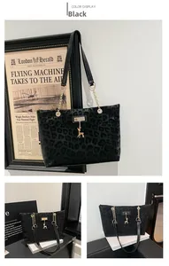 Dettaglio borsa tote leopardata nera con ciondolo a cervo dorato e catena oro