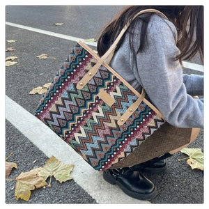Detail der böhmischen Stricktasche mit buntem Zickzackmuster und Ledergriffen