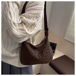 Sac hobo à motif léopard avec bandoulière en nylon porté sur un pull en maille beige