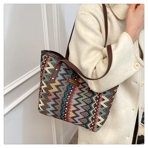 Detail of colorful chevron woven tote bag with brown leather handles and rivets