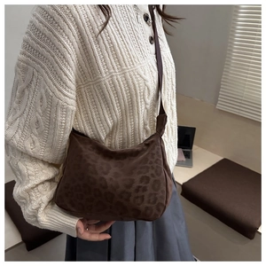 Sac hobo marron foncé à imprimé léopard porté avec un pull en maille blanc