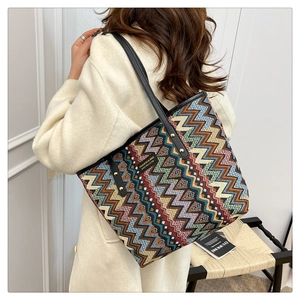 Close-up of colorful zigzag jacquard fabric and black leather handles on tote bag