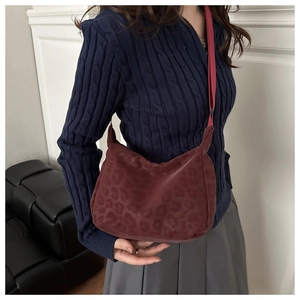 Dettaglio borsa shopper bordeaux con stampa leopardata e tracolla larga in nylon rossa
