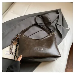 Détail du sac vintage marron foncé avec plaque en métal et sangle tressée déco