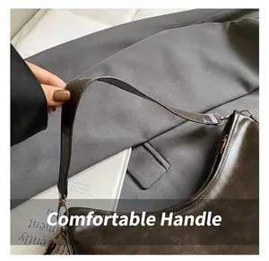 Détail du sac hobo en cuir marron rétro avec boucle dorée et bandoulière en gros plan
