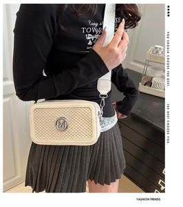 Vue détaillée du sac bandoulière tissé beige avec logo M et large bandoulière tendance