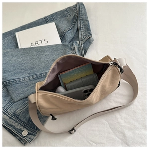 Geräumiges Innere der beige Nylon-Tasche zeigt Telefon und tägliche Essentials
