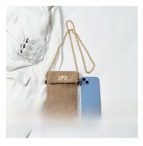 Compact brown quilted phone bag size comparison with smartphone and gold chain strap