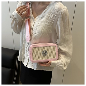 Détail du sac bandoulière rose et beige avec sangle large et logo M métallique