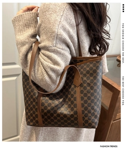 Detailed view of vintage large tote bag featuring brown monogram pattern and leather straps