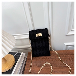 Detail of a black quilted mobile phone bag featuring a gold metal twist lock and chain strap