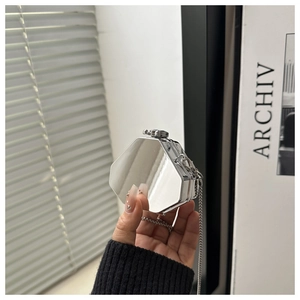 Détail d'un mini sac hexagonal argenté effet miroir avec une fine chaîne en métal
