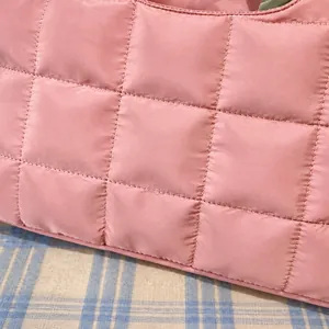 Détail du porte-documents matelassé rose clair avec tissu en nylon imperméable et coutures