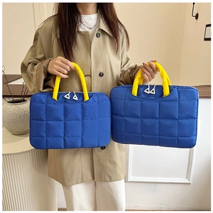 Détail du sac d'ordinateur matelassé bleu marine avec anses jaunes et double fermeture