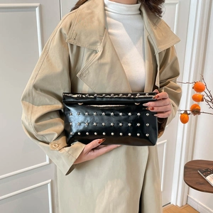 Schicke schwarze Nietenumschlag-Clutch von einem Modell in minimalistischem Stil gehalten