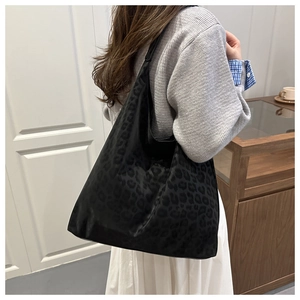 Detalle del bolso tote negro con estampado de leopardo mostrando gran capacidad y asa de hombro
