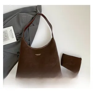 Detail of dark brown hobo bag with matching pouch and stylish suede texture