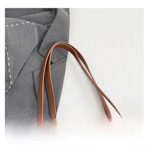 Detail view of the brown leather handle and leopard print faux fur on a tote bag