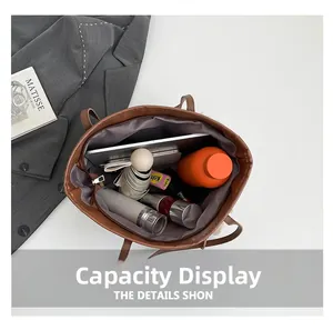 Large capacity interior of brown faux leather tote bag holding a tablet and bottles