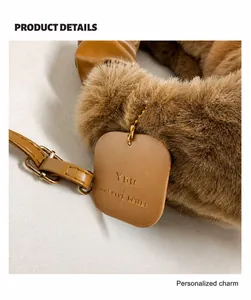 Detail of brown faux fur bag with leather strap and 'YOU deserve better' pendant tag