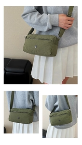 Detail view of army green nylon crossbody bag with multi-pocket design and adjustable strap