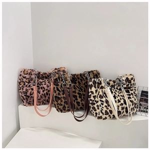 Detailed view of three leopard print faux fur tote bags with metal chain shoulder straps